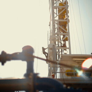 Worker climbing up the side of a well site