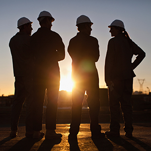 Silhouette of workers at oil refinery